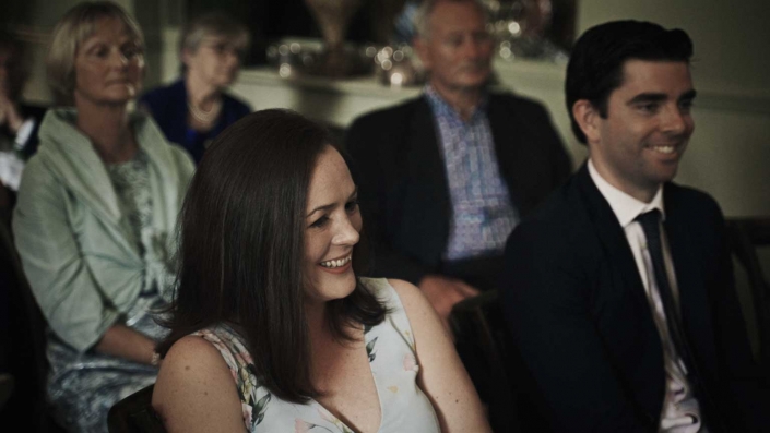 Smiling friends watching at wedding vows