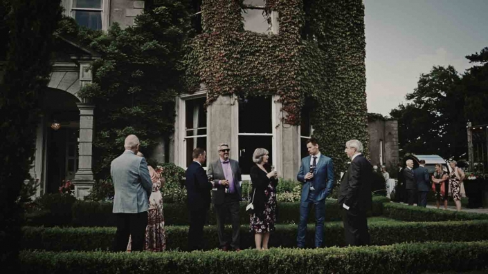 Conversation of wedding guest with Tinakilly House in background