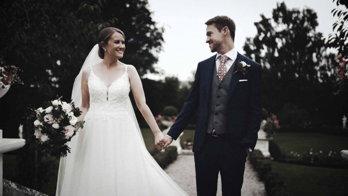 Jayne is holding groom hand and looking to eyes
