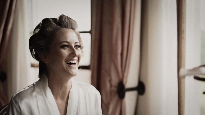 Bride is smiling after her make up is done