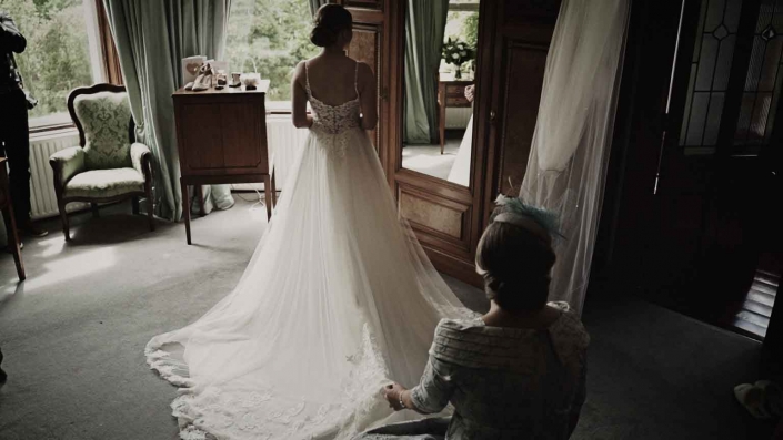 Mom fixing and admiring Jayne's wedding dress