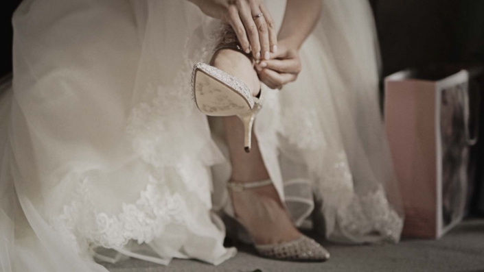 Bride is putting her wedding shoes