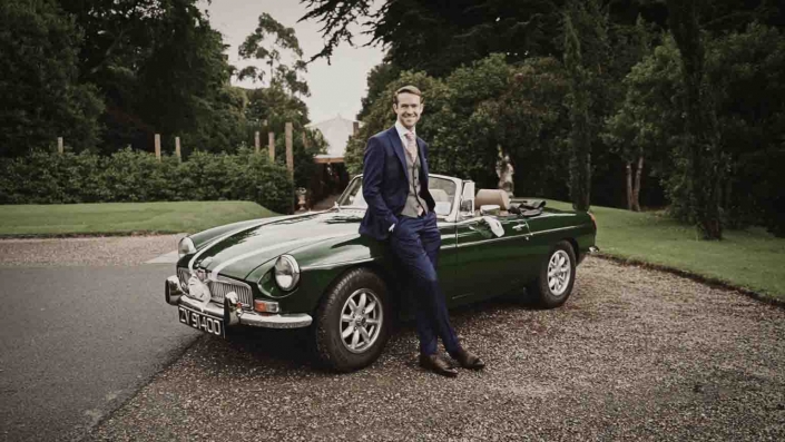 John standing with wedding car