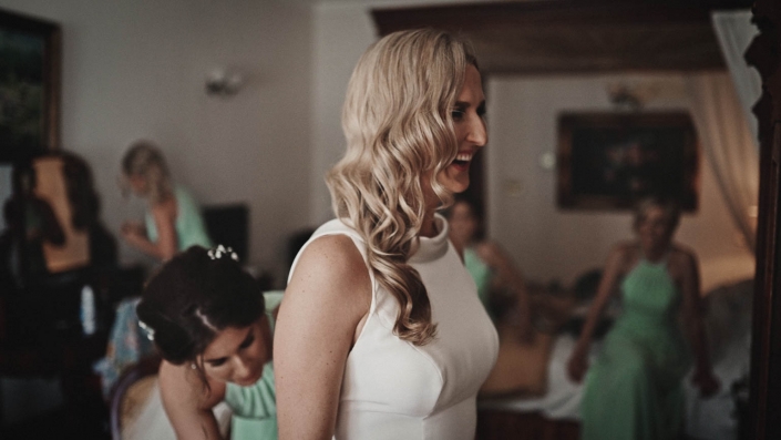 Smiling bride watching at her self in mirror