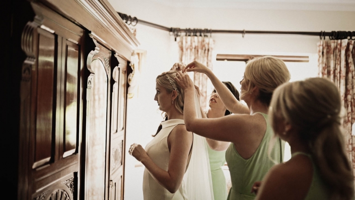 bridesmaids putting wedding veil