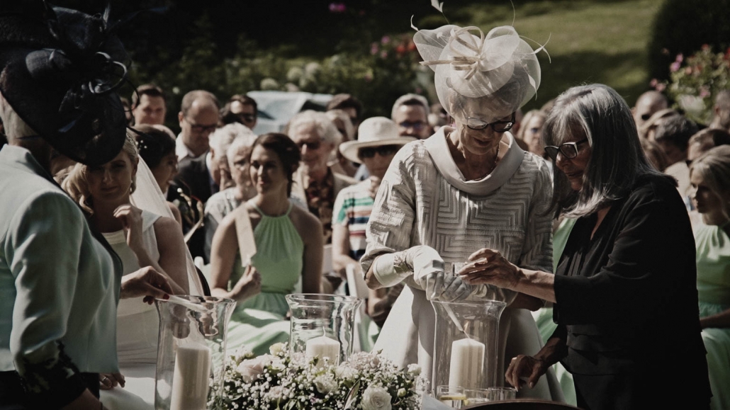 booth mothers rising candles on outside wedding ceremony