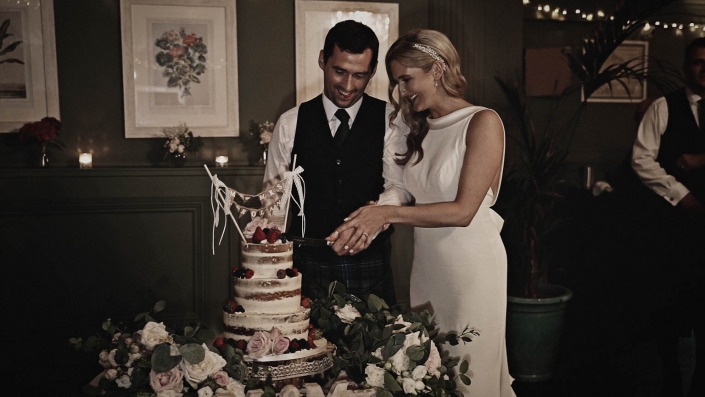 Bride cutting cake together with groom in Tinakilly House