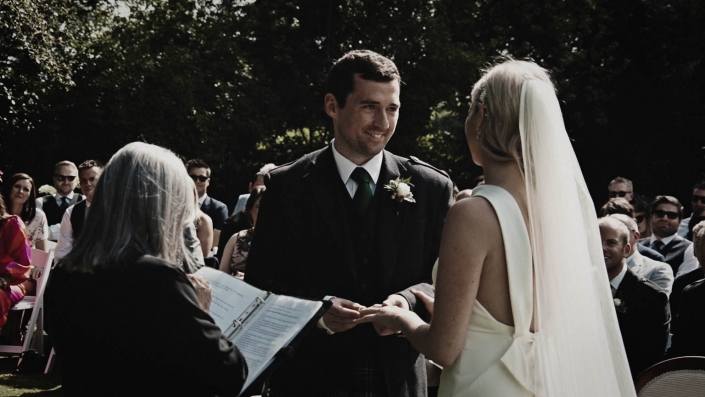Groom is putting wedding rings on bride finger