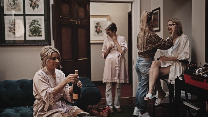 Bridesmaid is opening champagne