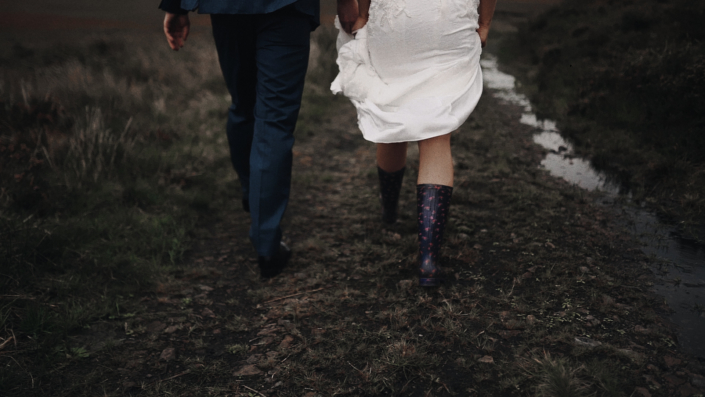 Bride wearing wellingtons and walk with groom.