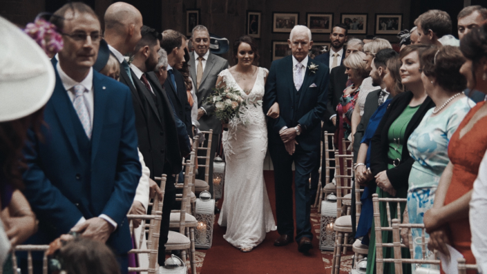 Bride walking with her father down aisle.