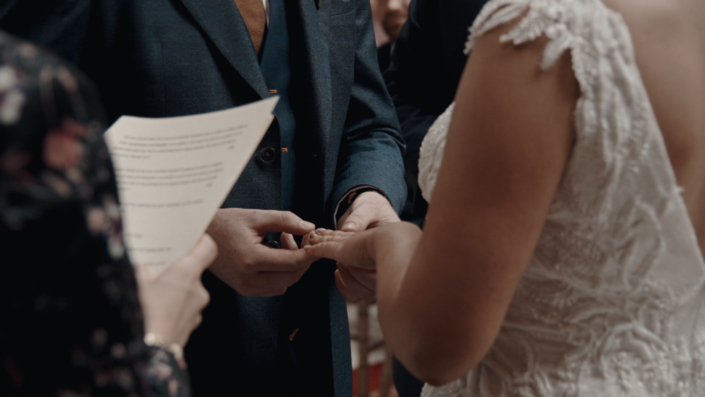 Daniel is putting wedding ring on Alison finger.