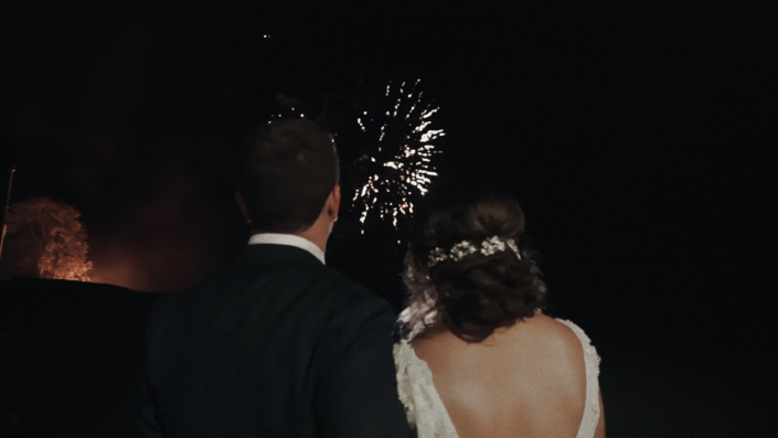 Bride with groom are admiring fire works.