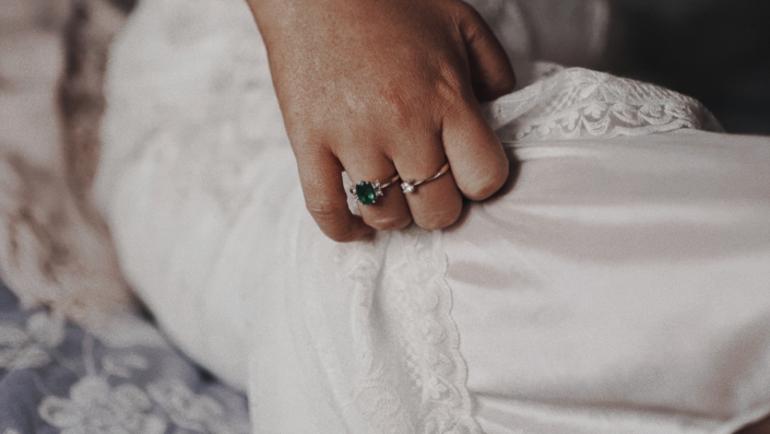 emerald engagement ring on bride hand