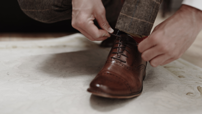 groom is tiding shoes